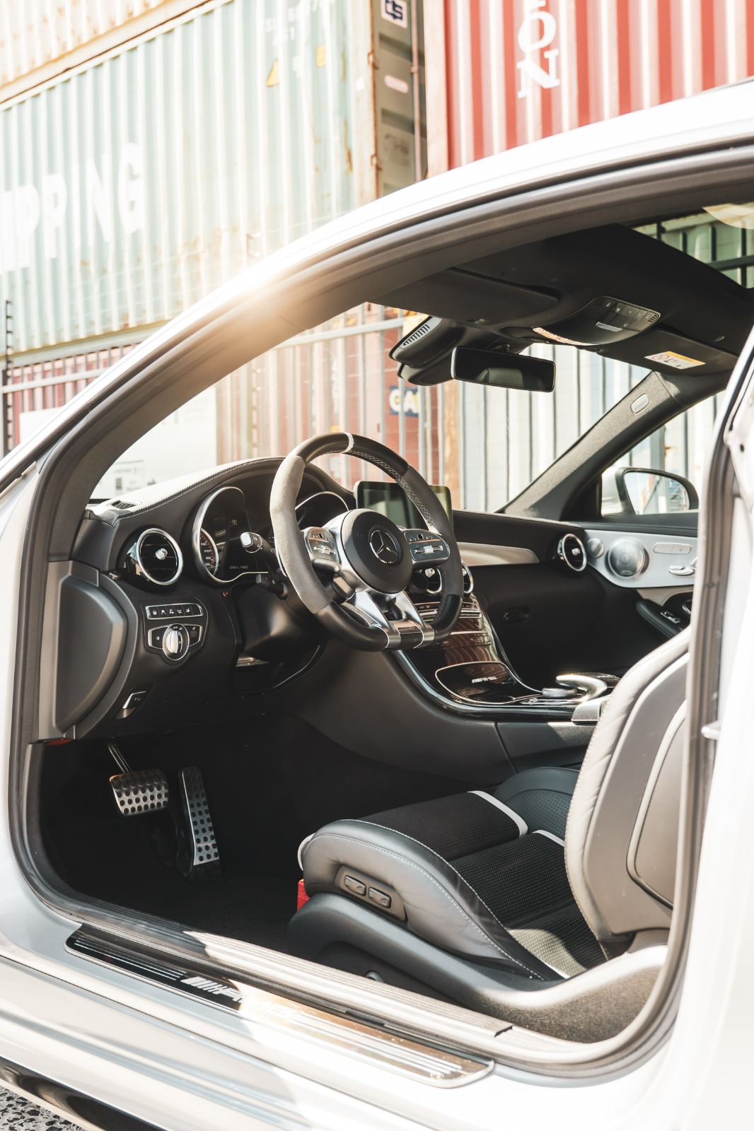 Interieur van een witte Mercedes-AMG C-Klasse met AMG-stuur en sportstoelen